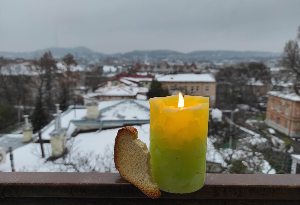 A memorial candle and a slice of bread are pictured Nov. 26 in Ukraine. Basilian Sr. Yeremiya Steblyna placed the candle and bread in her window on the Day of Remembrance for the Holodomor Victims, as a sign that "even with fields of wheat, my nation was starving in the 1933 famine in Ukraine." (Courtesy of Yeremiya Steblyna)