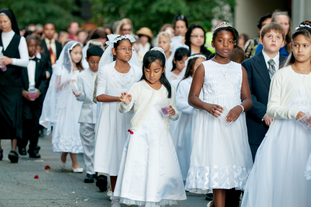Children receiving first Communion scatter rose petals during a eucharistic procession through downtown Charlotte, North Carolina, in 2014. (CNS/Catholic News Herald/Bill Washington) Children receiving first Communion scatter rose petals during a eucharistic procession through downtown Charlotte, North Carolina, in 2014. (CNS/Catholic News Herald/Bill Washington)