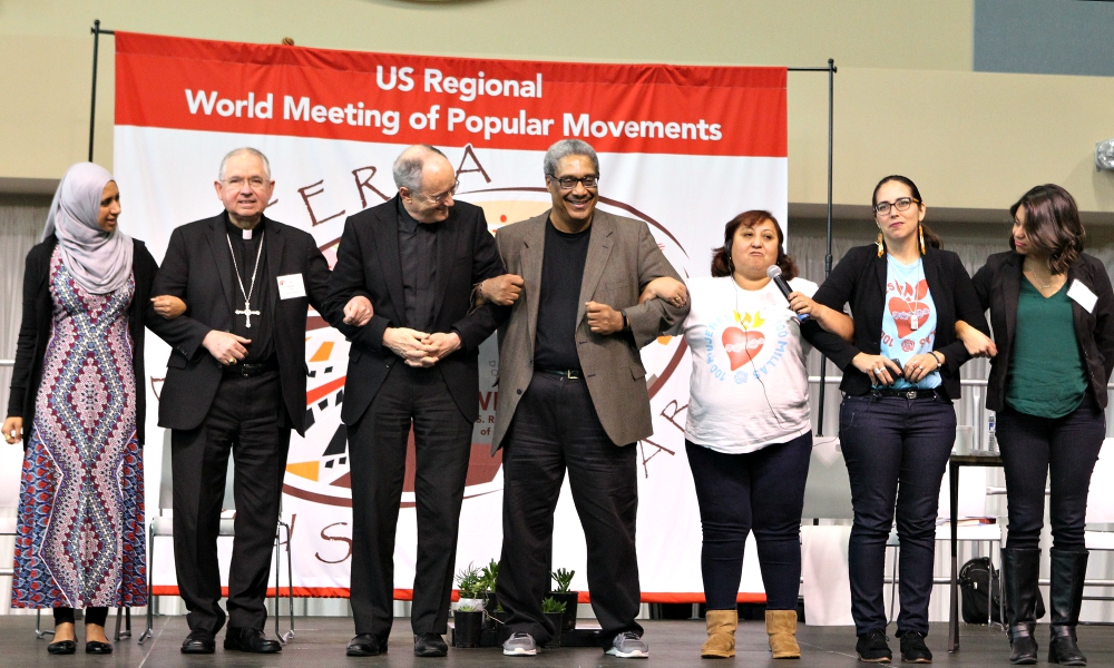 Los Angeles Archbishop José Gomez, second from left, links arms with other participants in a panel discussion on migration issues Feb. 17, 2017, during the U.S. Regional World Meeting of Popular Movements in Modesto, California. (CNS/Dennis Sadowski) Los Angeles Archbishop José Gomez, second from left, links arms with other participants in a panel discussion on migration issues Feb. 17, 2017, during the U.S. Regional World Meeting of Popular Movements in Modesto, California. (CNS/Dennis Sadowski)