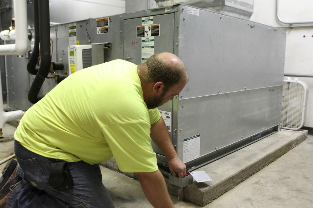 Technician Brian Wayson of AirStream Mechanical in Cincinnati checks wiring on a high-efficiency air conditioning unit at St. John Fisher Church in Newtown, Ohio, Aug. 17, 2017. (CNS) Technician Brian Wayson of AirStream Mechanical in Cincinnati checks wiring on a high-efficiency air conditioning unit at St. John Fisher Church in Newtown, Ohio, Aug. 17, 2017. (CNS)