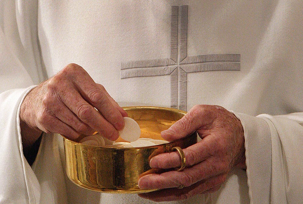 A priest prepares to distribute Communion during Mass in Washington. (CNS/Bob Roller) A priest prepares to distribute Communion during Mass in Washington. (CNS/Bob Roller)