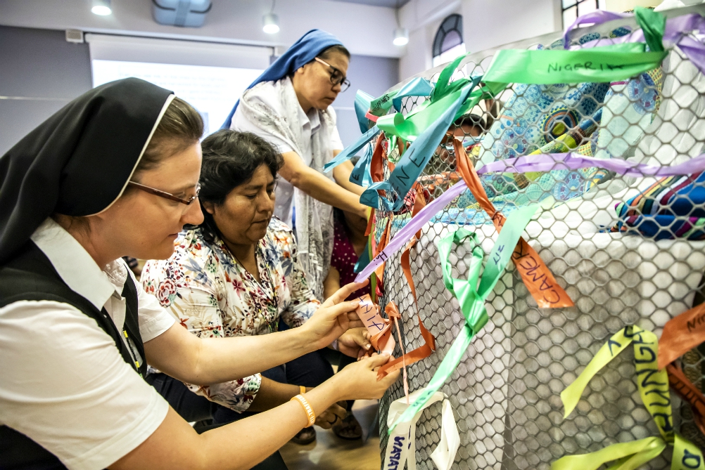 Sisters tie ribbons with the name of their country and a trafficking survivor with whom they have worked with Sept. 27 at the 10th anniversary gathering of Talitha Kum in Rome. (Courtesy of Talitha Kum) Sisters tie ribbons with the name of their country and a trafficking survivor with whom they have worked with Sept. 27 at the 10th anniversary gathering of Talitha Kum in Rome. (Courtesy of Talitha Kum)