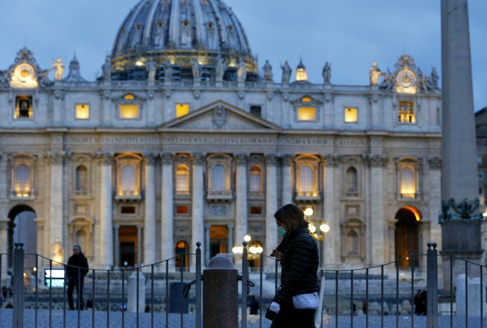 A woman wearing a mask for protection from the coronavirus walks outside St. Peter's Square at the Vatican March 9. (CNS/Paul Haring) A woman wearing a mask for protection from the coronavirus walks outside St. Peter's Square at the Vatican March 9. (CNS/Paul Haring)