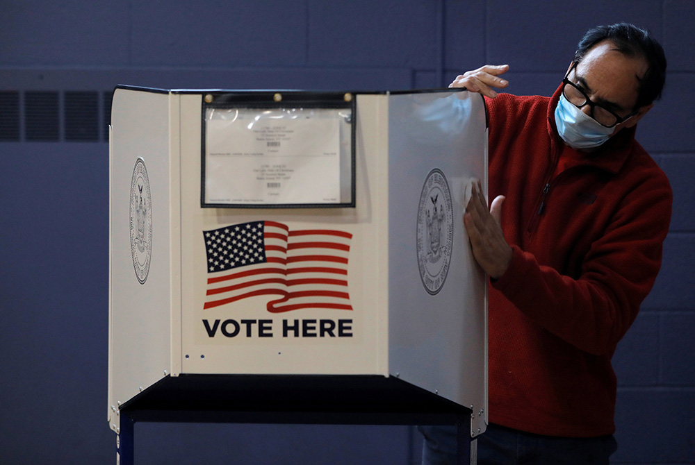 A man sanitizes a voting booth to fight the spread of the coronavirus disease at a polling station Oct. 25 on Staten Island, New York. (CNS/Reuters/Andrew Kelly) A man sanitizes a voting booth to fight the spread of the coronavirus disease at a polling station Oct. 25 on Staten Island, New York. (CNS/Reuters/Andrew Kelly)