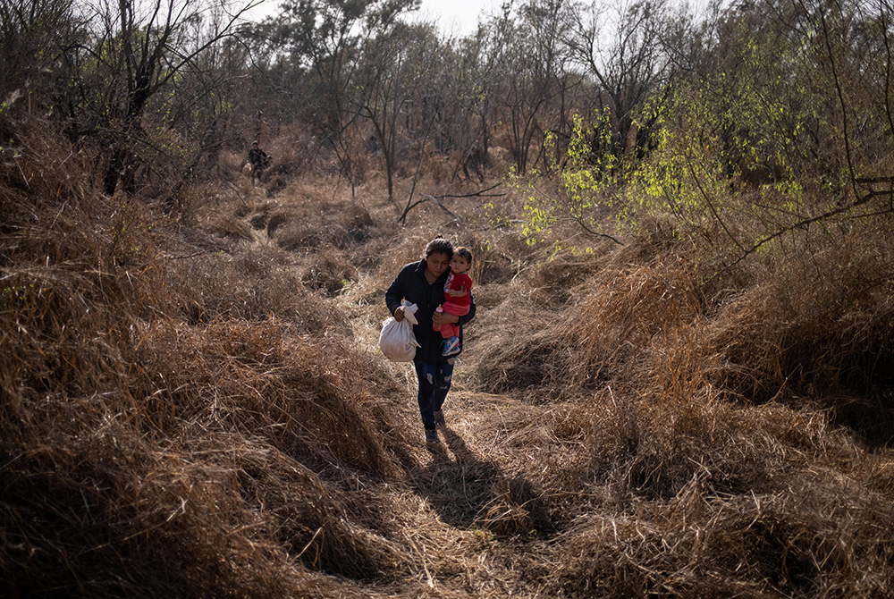 A Honduran migrant carries her baby into Penitas, Texas, after crossing the Rio Grande River from Mexico March 10. (CNS/Adrees Latif, Reuters) A Honduran migrant carries her baby into Penitas, Texas, after crossing the Rio Grande River from Mexico March 10. (CNS/Adrees Latif, Reuters)