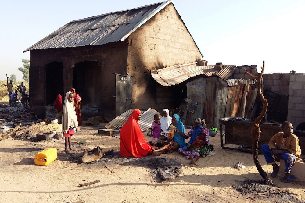 Family near damaged home in Bulabulin, Nigeria A family is pictured sitting near a damaged home after an attack by suspected members of the Islamist Boko Haram insurgency, Nov. 1, 2018, in Bulabulin, Nigeria. (CNS/Reuters/Kolawole Adewale)