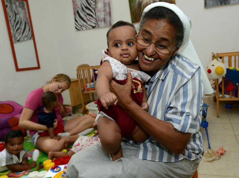 Nun holds child.