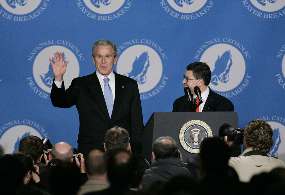 Then-President George W. Bush waves as he arrives at the fourth annual National Catholic Prayer Breakfast April 13, 2007, in Washington. The president was introduced by Leonard Leo, right, then-executive vice president of the Federalist Society for Law and Public Policy Studies. (CNS/Paul Haring)