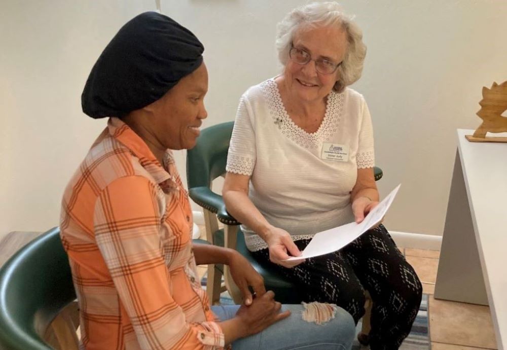 1. Sr. Judith Dohner helps a Haitian immigrant woman with paperwork. (Courtesy of Judith Dohner)