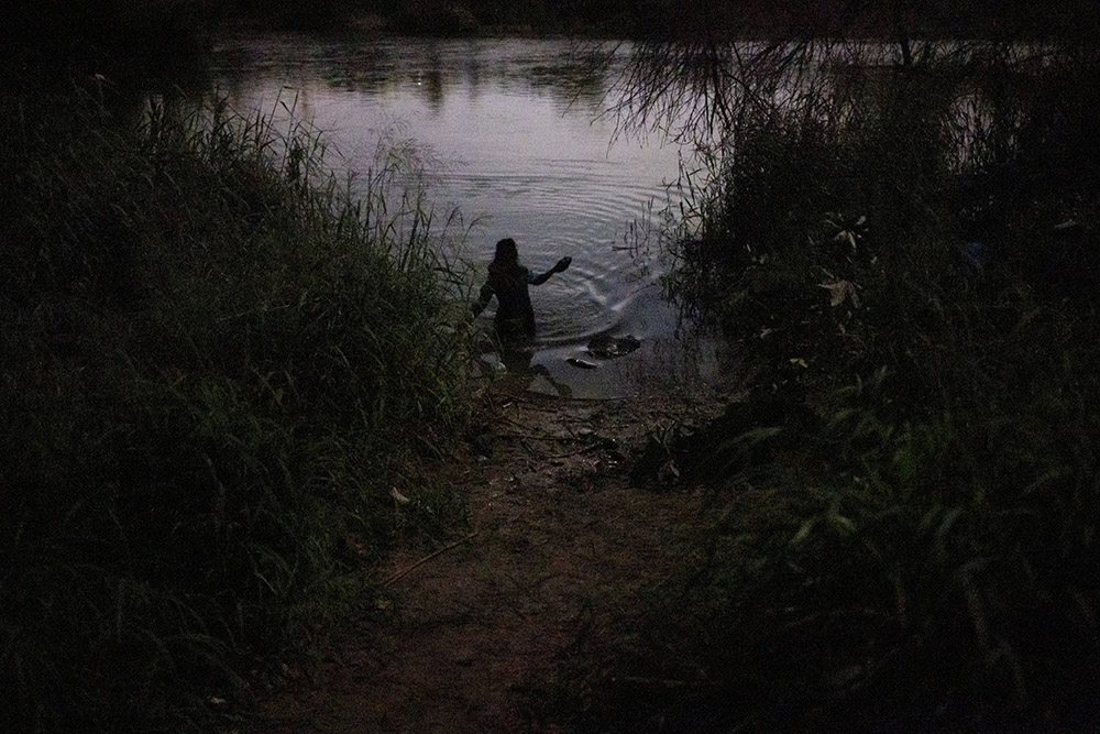 An unaccompanied minor from Honduras wades across the Rio Grande headed for Roma, Texas, May 13, 2022. (CNS/Reuters/Adrees Latif)