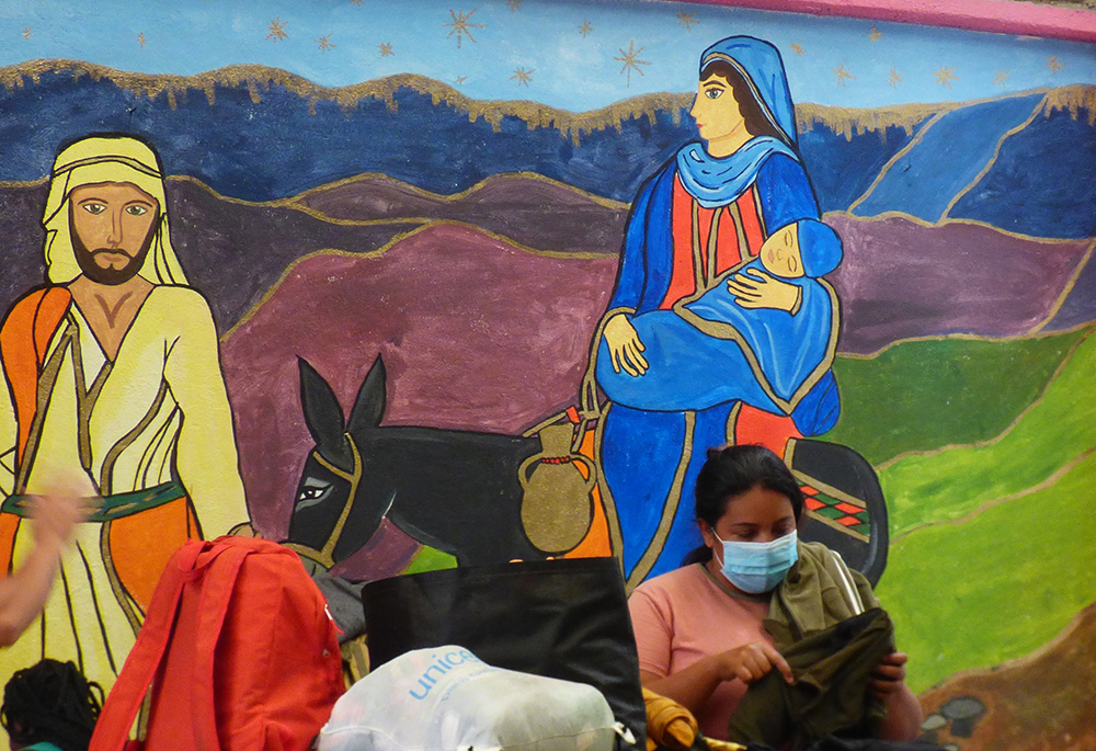 Mural de José y María en el refugio para migrantes Cafemin, en Ciudad de Méxic Una mujer recoge sus pertenencias frente a un mural de José y María en el refugio para migrantes Cafemin, en Ciudad de México, el 24 de agosto. La Hna. María Soledad Morales Ríos, una de las hermanas Josefinas cuya congregación gestiona el refugio, afirmó que su carisma consiste en cuidar de los pobres, incluidos los migrantes, del mismo modo que José y María cuidaron de Jesús. (Foto: GSR/Rhina Guidos)
