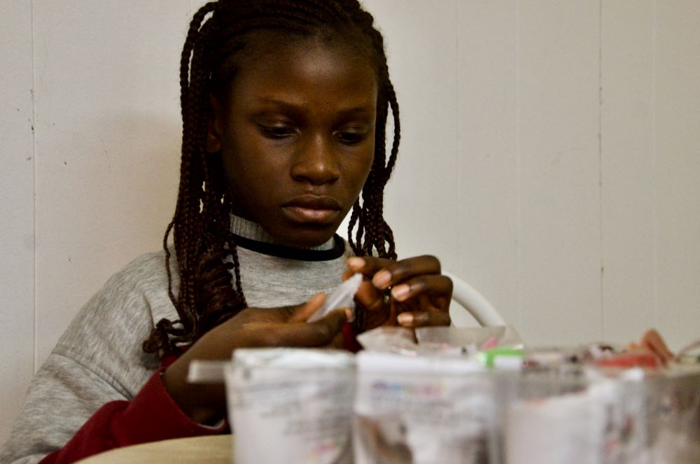 Aminata hace pequeños adornos para un árbol de Navidad de papel de construcción el 13 de diciembre de 2023, en el apartamento que ella y su hermana comparten en Chicago. (Foto: GSR/Dan Stockman)