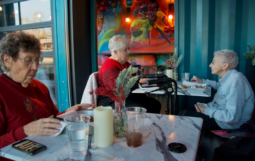 La hermana de la Misericordia JoAnn Persch (de izquierda a derecha), la asociada de la Misericordia Carol Conway y la hermana de la Misericordia Pat Murphy disfrutan de un almuerzo el 13 de diciembre en una de las paradas que hacen cuando visitan a las familias migrantes que patrocinan en Chicago. (Foto: GSR/Dan Stockman)
