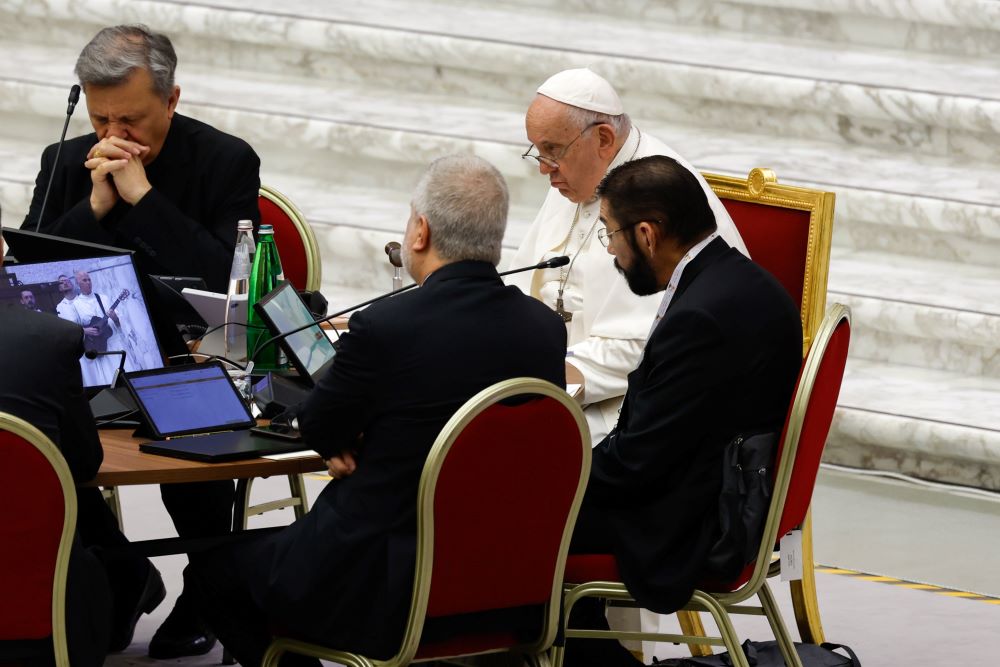 Four men at a table including Pope Francis and Bishop Daniel Flores.