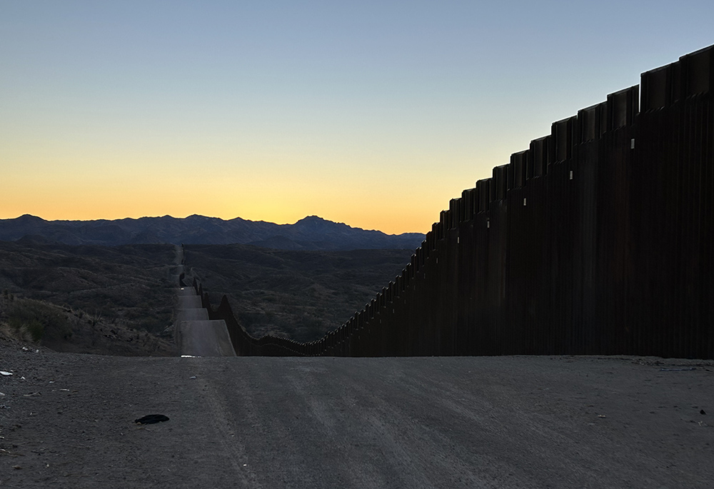 The sun rises above the horizon along the U.S.-Mexico border wall. (Peter Tran)