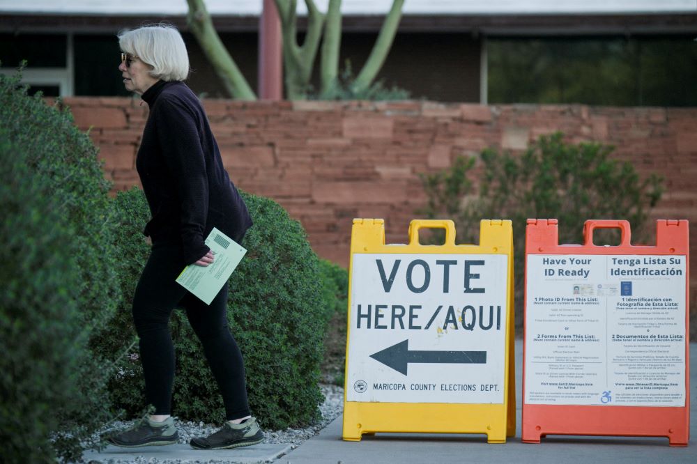 A voter carries a ballot to a polling place in Phoenix as Arizona's Democratic and Republican parties held primary elections on March 19.