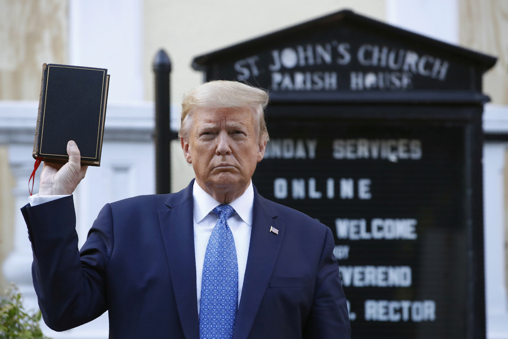 Trump, St. John's Episcopal, Washington D.C. Donald Trump holds bible inf front of church sign.