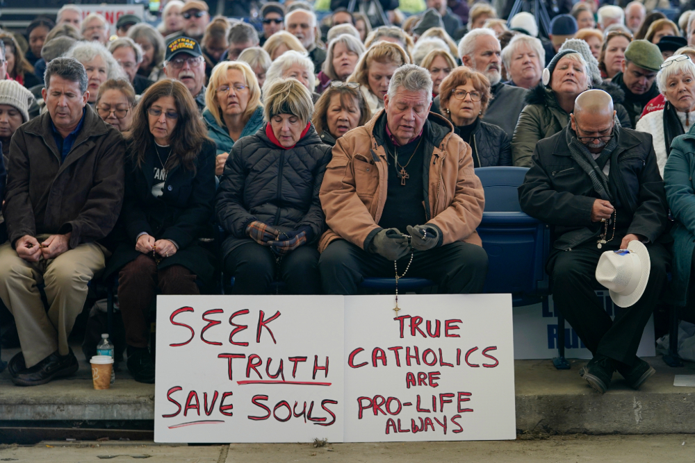 Protesters praying rosary People pray rosary outside US Bishops Conference meeting in Baltimore.