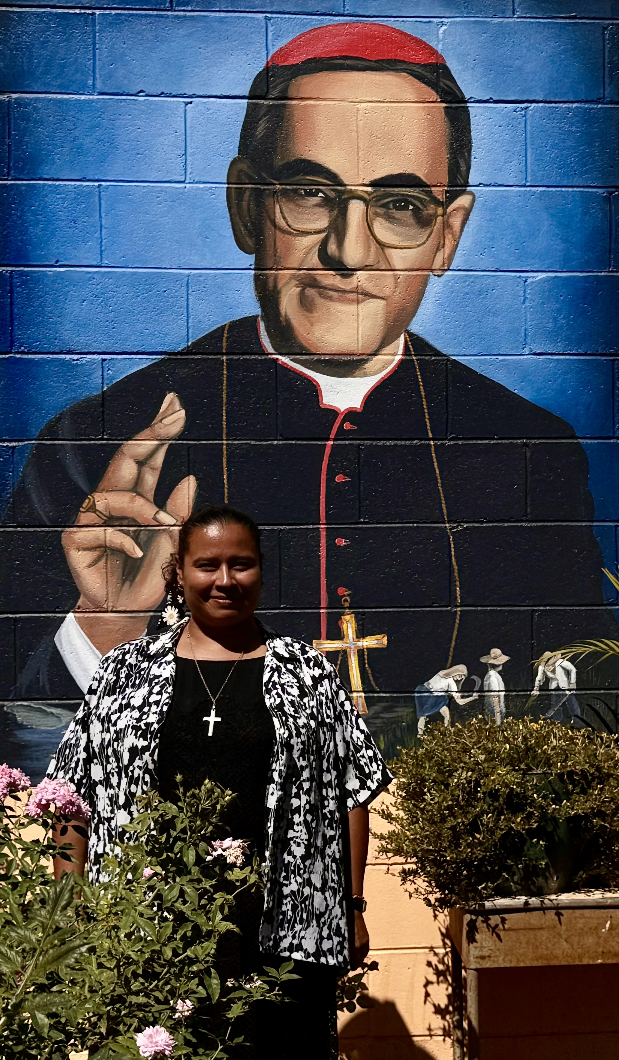 Notre Dame Sr. Sandra Margarita Sierra Flores poses for a photo in front of a mural of St. Oscar Romero on Jan. 27, 2024, in Chalatenango, El Salvador. She said she is inspired by the life of the saint, his writings and his devotion to the poor, which has influenced her ministry. (GSR photo/Rhina Guidos)
