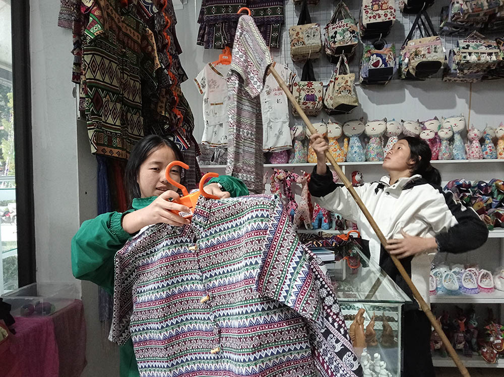 Teresa Thao Thi Bau (left) and another student sell clothes and souvenirs at a shop in the compound of Sa Pa Church in Sa Pa town of the northern province of Lao Cai, Vietnam. (Joachim Pham)