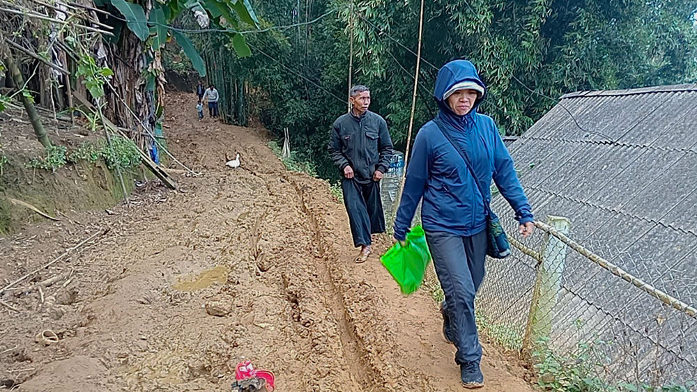 Sr. Mary Hoang Thi Phuong, a member of the Lovers of the Holy Cross of Hung Hoa, walks on a muddy path to San 2 Mission Station in Sa Pa town of the northern province of Lao Cai, Vietnam, on Dec. 10, 2023. (Joachim Pham)