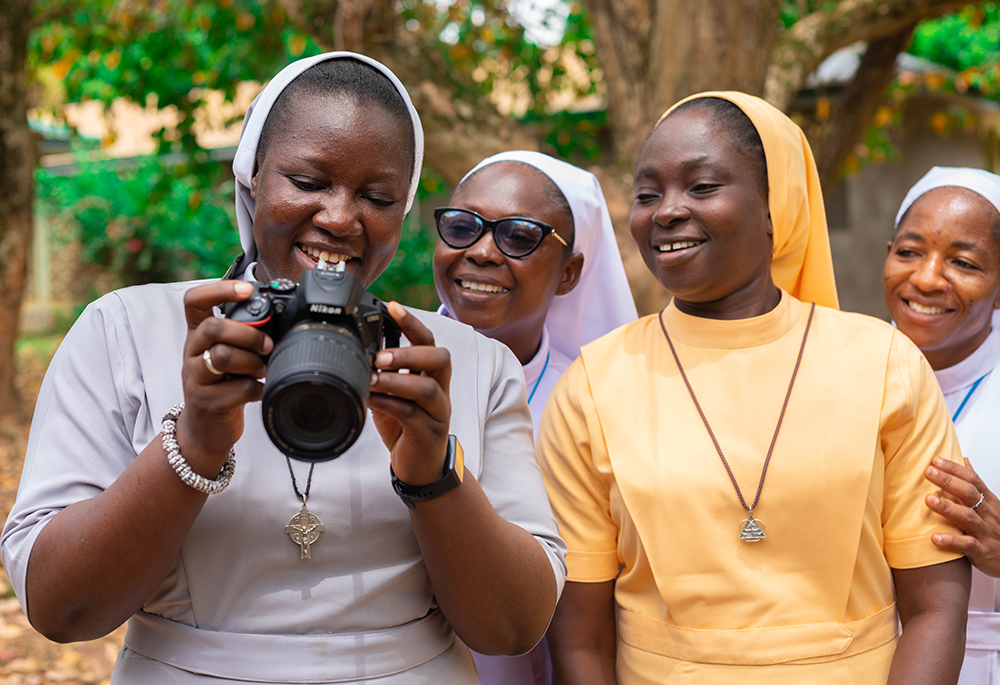 Handmaids of the Holy Child Jesus Sr. Emmanuella Dakurah (holding camera), Sisters of Mary Immaculate Sr. Juliana Atuuna, Daughters of the Most Holy Trinity Sr. Patricia Akoto, and Sisters of Mary Immaculate Sr. Gloria Duongnaa practice using a camera at a training session May 9 at Santasi in Ghana's Kumasi Archdiocese. (Newswatchgh.com/Damian Avevor)