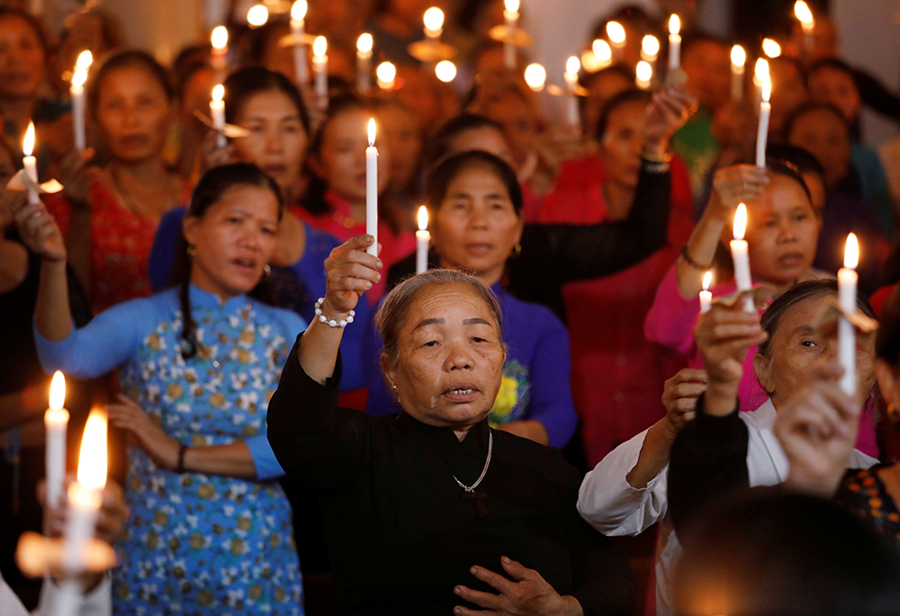 Women hold candles at a church Oct. 26, 2019, in My Khanh, Vietnam. The service was for 39 people found dead in the back of a truck at the Port of Tilbury Oct. 23, in Essex, England. (CNS/Reuters/Kham)