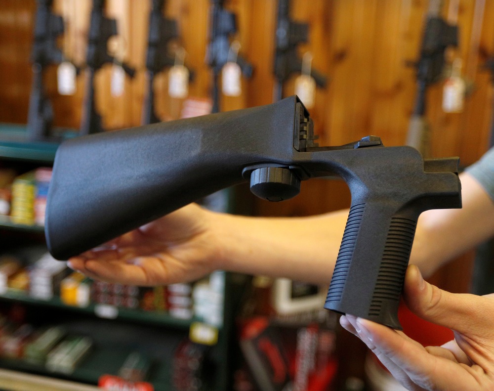 Bump stock Person, face not shown, displays a bump stock in their hands.
