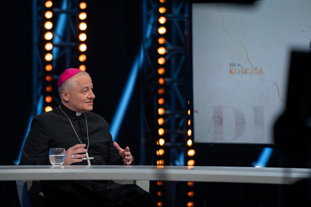 Diocese of Sosnowiec Bishop, in black cassock and purple zucchetto, talks on television.