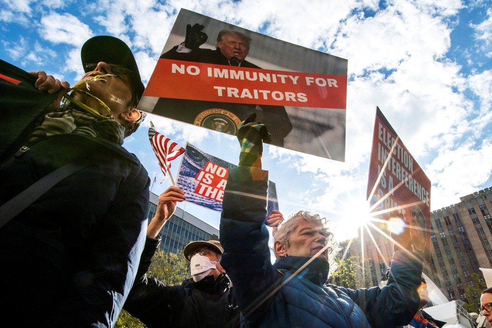 Supreme Court, presidential immunity Protesters hold signs against presidential immunity