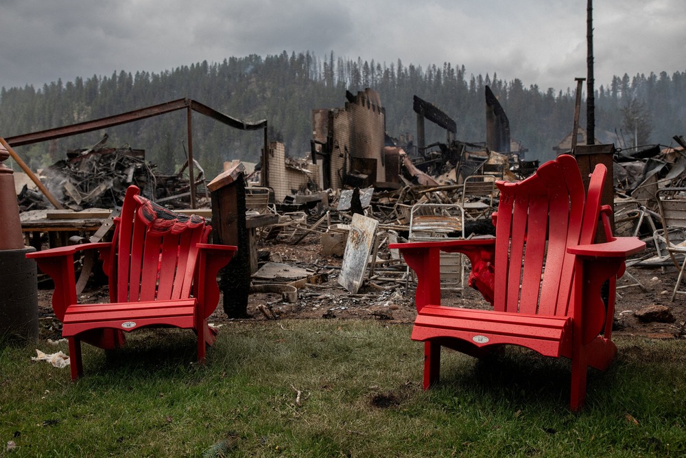 Wildfire in Alberta, Canada, 2024. Melted lawn chairs shown in front of incinerated house and smokey, charred landscape.