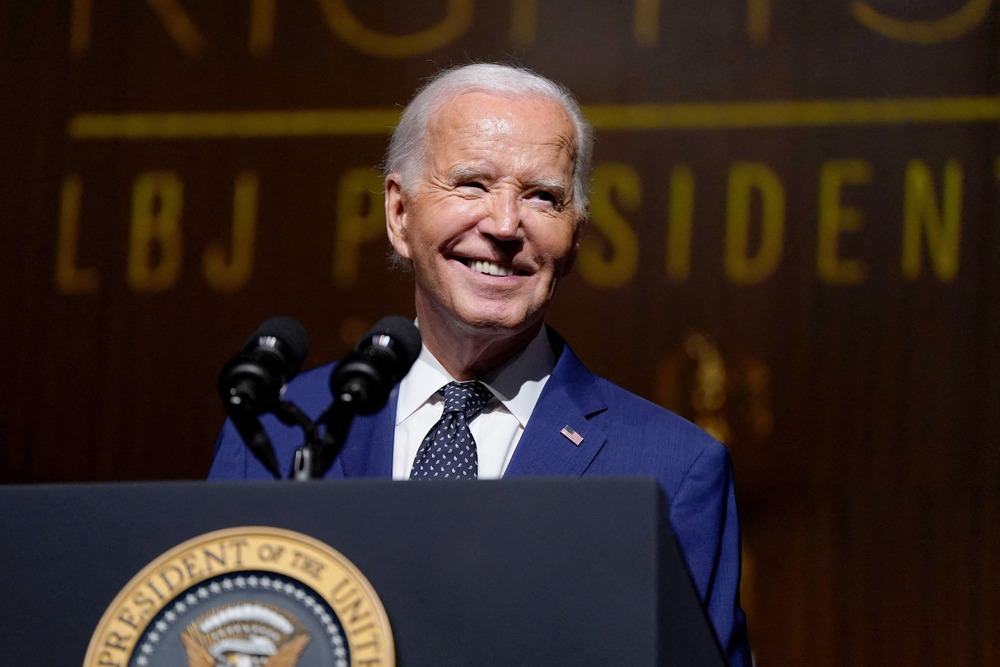 President Biden, Lyndon B. Johnson Presidential Library, Austin, Texas, 2024. Biden smiles from behind podium.