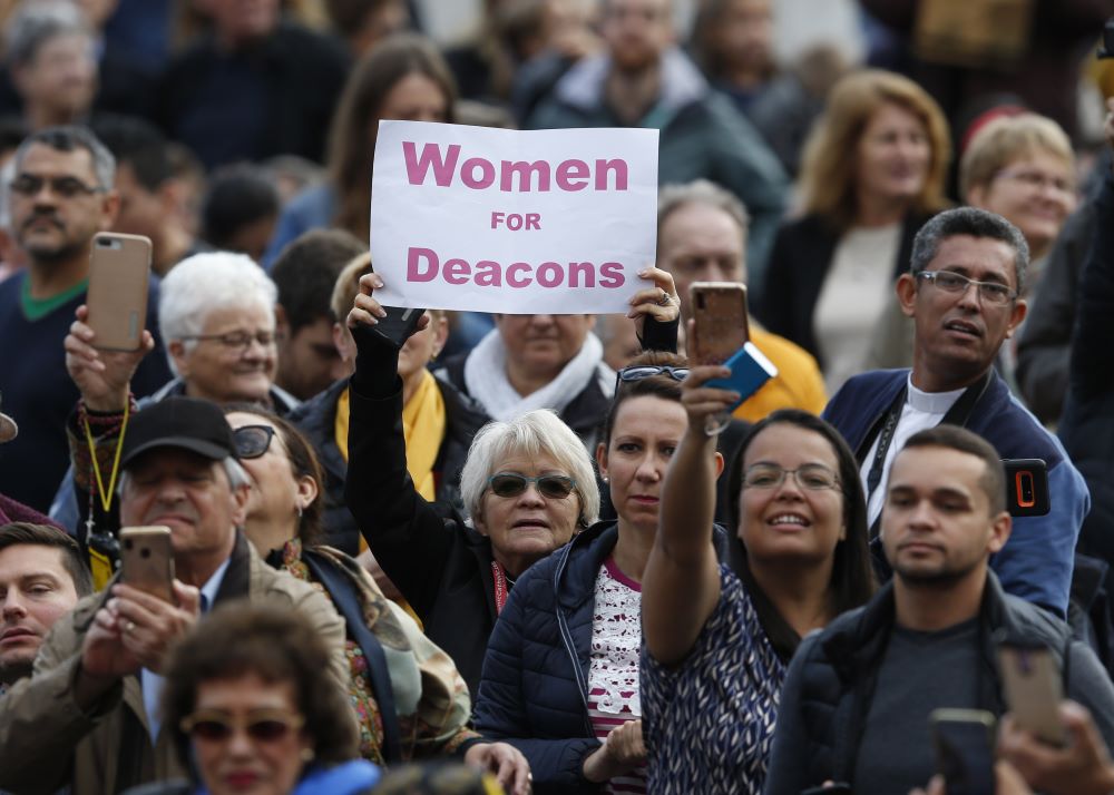 A woman holds a sign in support of women deacons as Pope Francis leads his general audience in St. Peter's Square at the Vatican Nov. 6, 2019. (CNS/Paul Haring) A woman holds a sign in support of women deacons as Pope Francis leads his general audience in St. Peter's Square at the Vatican Nov. 6, 2019. (CNS/Paul Haring)