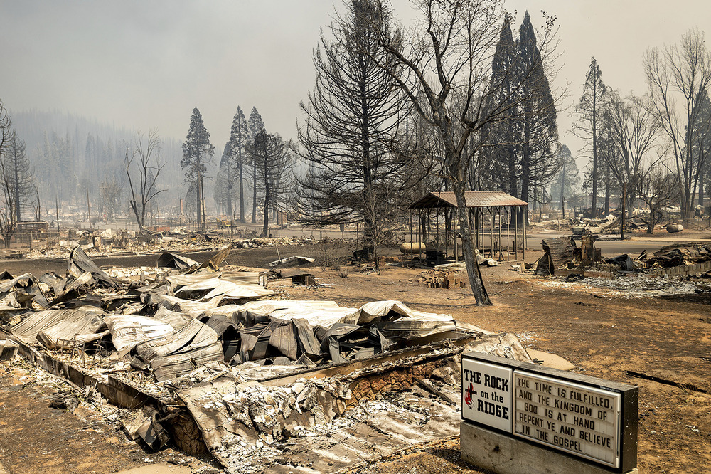Destroyed church in Plumas County, California. Marquee stands next to burnt ruins and scorched ground.
