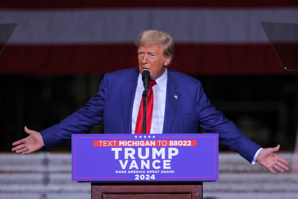 Donal Trump rally, Potterville, Mich., Aug. 29, 2024. Trump stands at podium, arms opened wide in gesture.