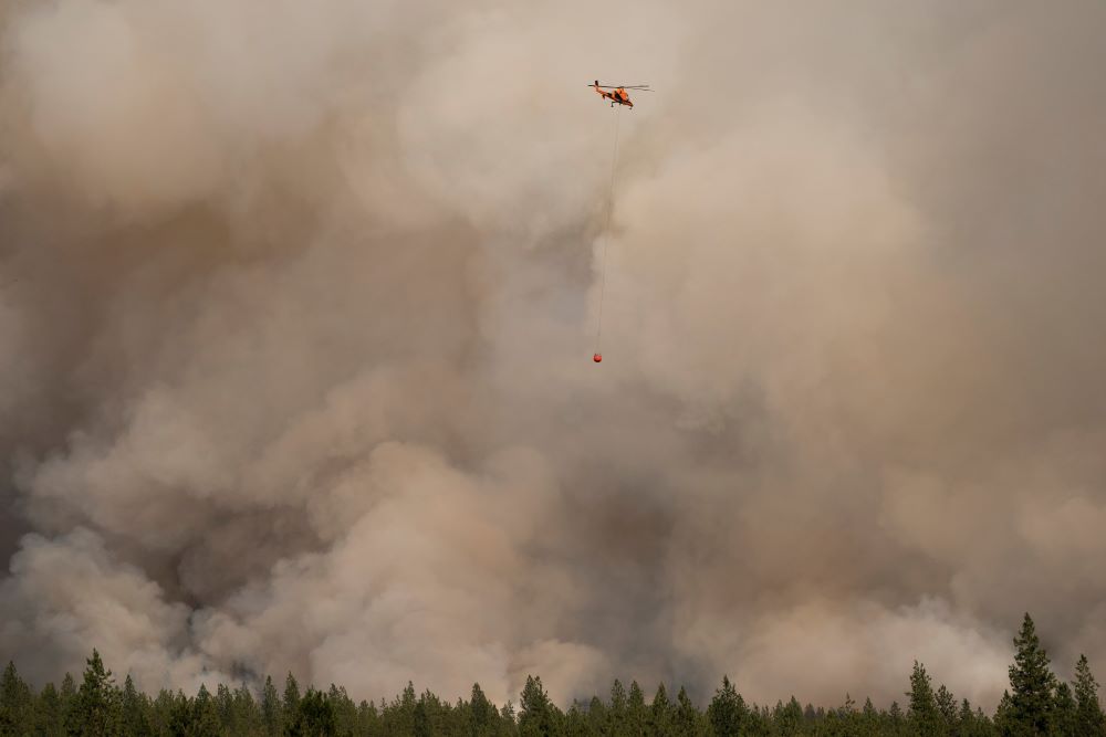 A helicopter in Nespelem, Wash., prepares to drop water on the Chuweah Creek Fire July 14, 2021. A helicopter in Nespelem, Wash., prepares to drop water on the Chuweah Creek Fire July 14, 2021.