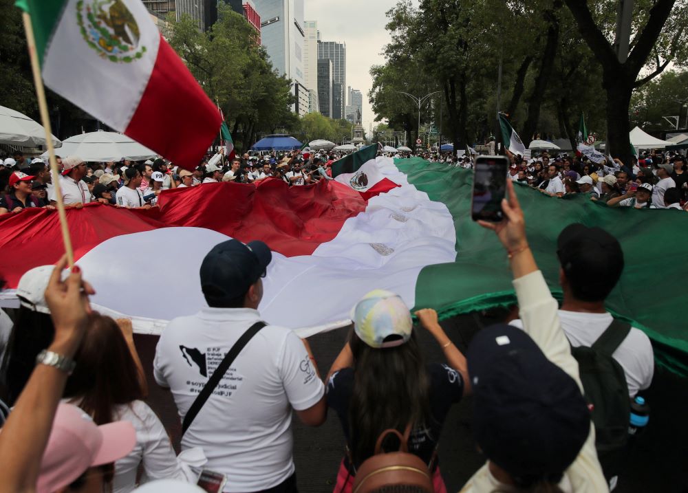 Manifestantes sostienen una bandera frente al edificio del Senado en Ciudad de México el 5 de septiembre, en señal de protesta contra la controvertida reforma del poder judicial del país, que da paso a una nueva era de elecciones para todos los jueces. La reforma aprobada fue impulsada por el presidente saliente. Manifestantes sostienen una bandera frente al edificio del Senado en Ciudad de México el 5 de septiembre, en señal de protesta contra la controvertida reforma del poder judicial del país, que da paso a una nueva era de elecciones para todos los jueces. La reforma aprobada fue impulsada por el presidente saliente. (Foto: Henry Romero/OSV News/Reuters)
