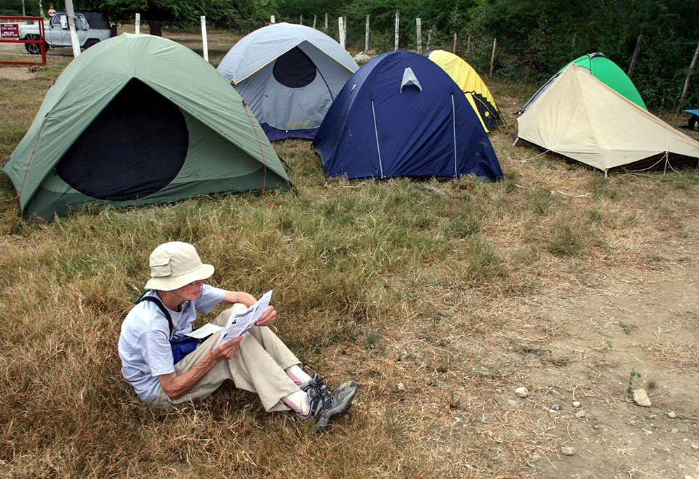 Sr. Anne Montgomery, a member of the Christian Peacemakers Team, reads outside the "Witness Against Torture" camp at the military zone boundary near the U.S. detention facility in Guantanamo Bay, Cuba, Dec. 13, 2005. (CNS/Reuters)