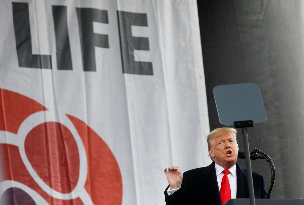 Then-President Trump, March for Life, Washington D.C., Jan. 24, 2020. Trump stands at podium in front of large banner gesturing while talking.