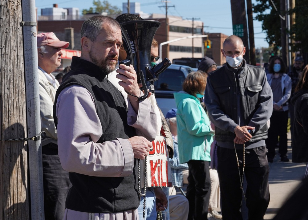 Father Fidelis Moscinski, Planned Parenthood protest, Long Island, N.Y., Sept. 19, 2020. The priest stands holding megaphone and rosary.