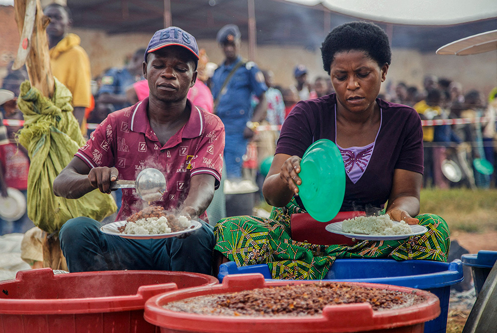 Burundian volunteers serve food to displaced families at Rugombo Stadium in Burundi, Feb. 18, 2025, after Congolese fled from renewed clashes between M23 rebels and the armed forces of the Democratic Republic of the Congo. (OSV News/Reuters/Evrard Ngendakumana)