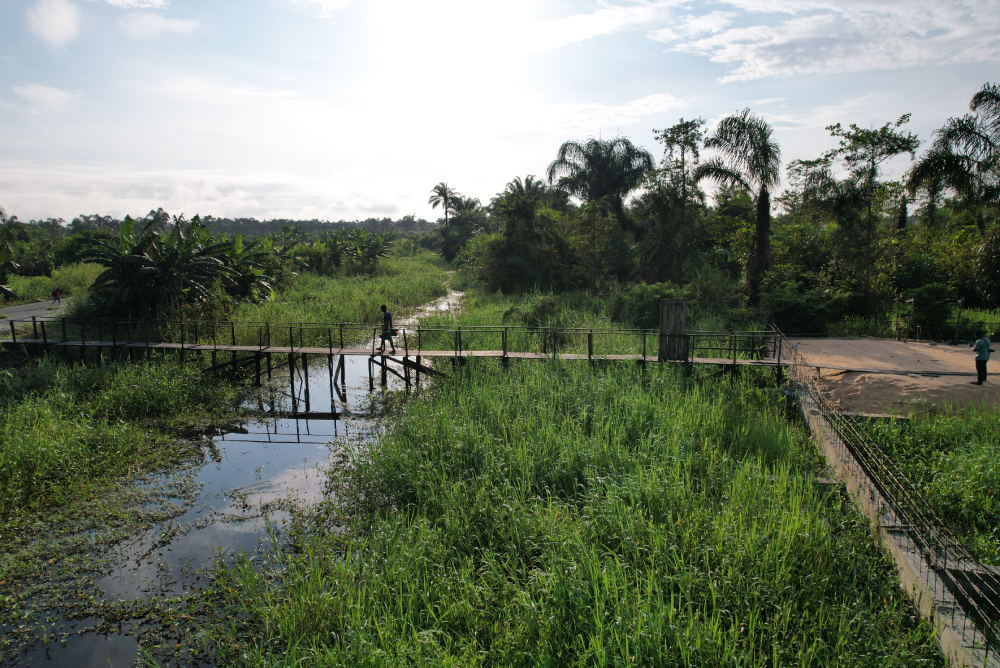 Wooden bridge to MMM convent in Torugbene Side view of the wooden bridge linking the Medical Missionaries of Mary sisters' convent, clinic, and the community. The sisters often go into the community to provide sensitization and intervention to the residents.