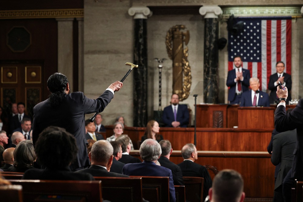 Rep. Al Green, D-Texas, Donald Trump joint session address, Washington D.C., March 4, 2025. Green shown from behind shaking cane while Trump, seated, smiles smugly.