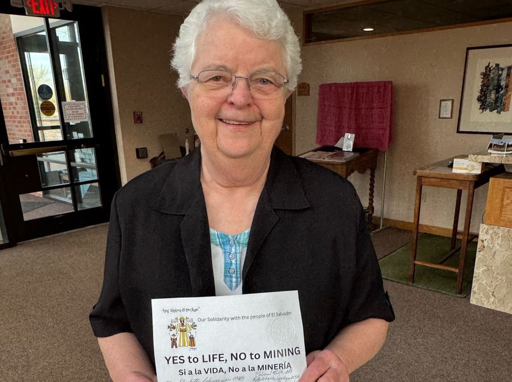 La hermana benedictina Mary Elizabeth Schweiger sostiene una petición contra la minería en El Salvador firmada el 24 de marzo por religiosas del monasterio de Mount St. Scholastica en Atchison, Kansas, EE. UU. Las benedictinas se unieron a las Hermanas de la Caridad de la cercana Leavenworth, así como a otros católicos de Kansas, mostrando su solidaridad con la Iglesia católica de El Salvador que lucha contra una nueva ley que permite la minería de metales. (Foto: GSR/Rhina Guidos)