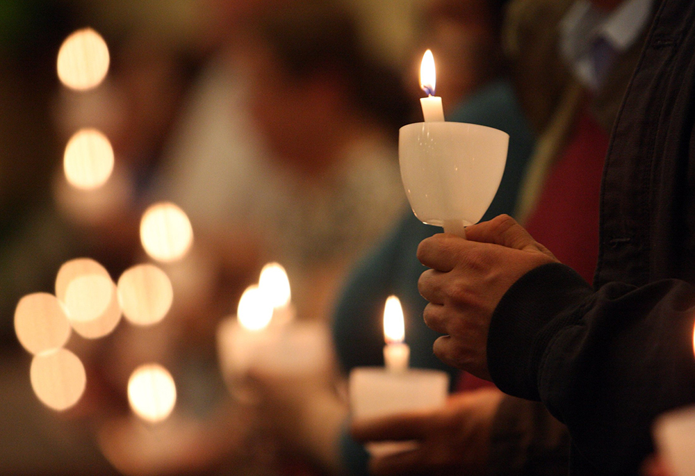 Pictured are worshippers holding candles in this 2012 photo. Church leaders have a crucial role and duty in rebuilding trust after the sexual abuse scandals involving clerics and other church representatives, writes Sr. Matilda Owolagba. (CNS file/Gregory A. Shemitz)