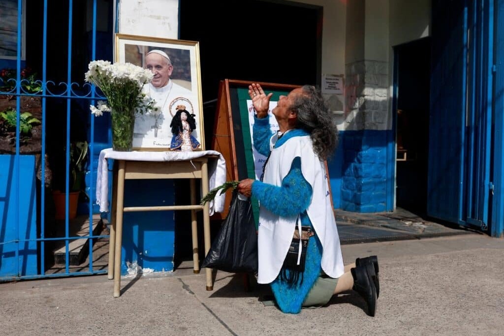 Gregoria Caceres prays next to a picture of Pope Francis placed outside the Virgin of Caacupé chapel in Buenos Aires, Argentina, April 21, 2025, after the death of Pope Francis was announced by the Vatican.