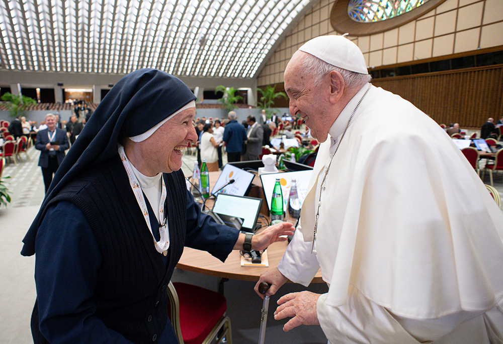 Pope Francis shares a laugh with Canadian Sister Chantal Desmarais, a member of the Sisters of Charity of St. Mary, before a session of the assembly of the Synod of Bishops in the Vatican's Paul VI Audience Hall Oct. 17, 2023. (CNS/Lola Gomez)