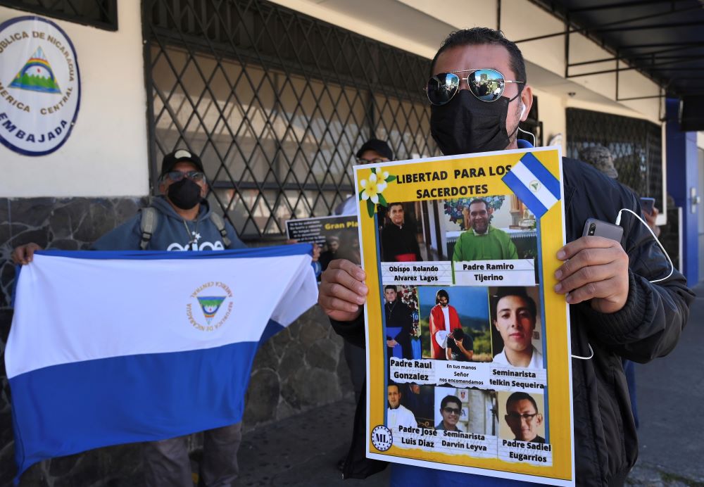 A Western Democratic Movement activist holds a poster with a message that reads in Spanish; "Free the priests."