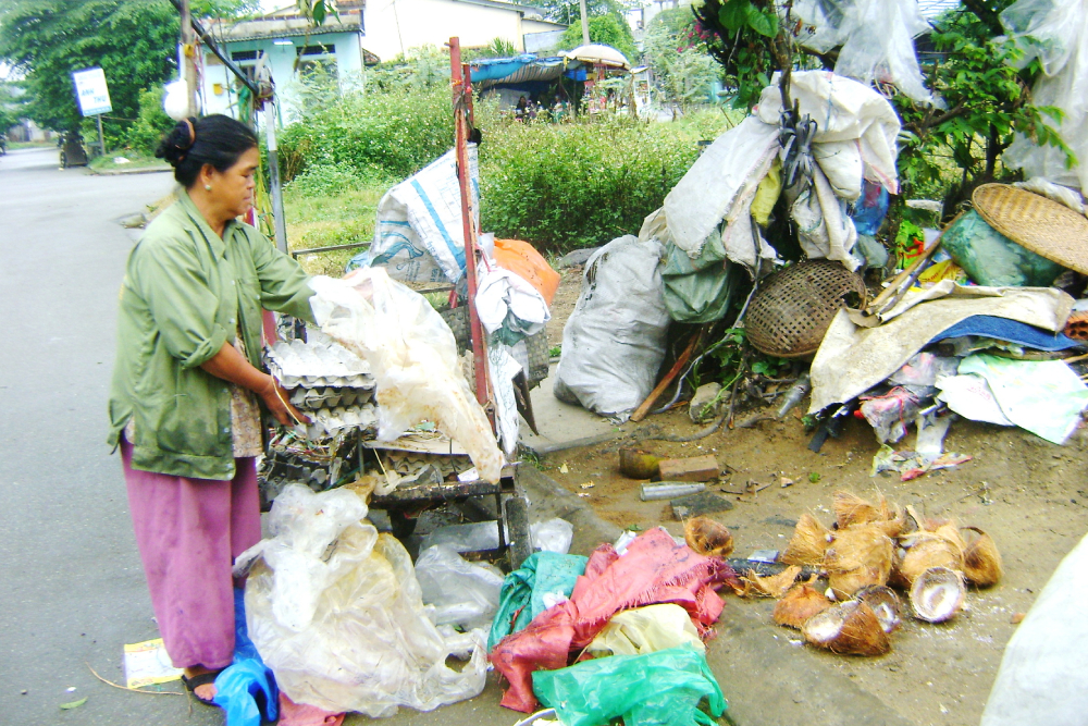 Scraps cart Nguyen Thi Voi loads her three-wheeled cart with scraps on Mar. 5 in Phong Dien district of Thua Thien Hue province. (Joachim Pham)