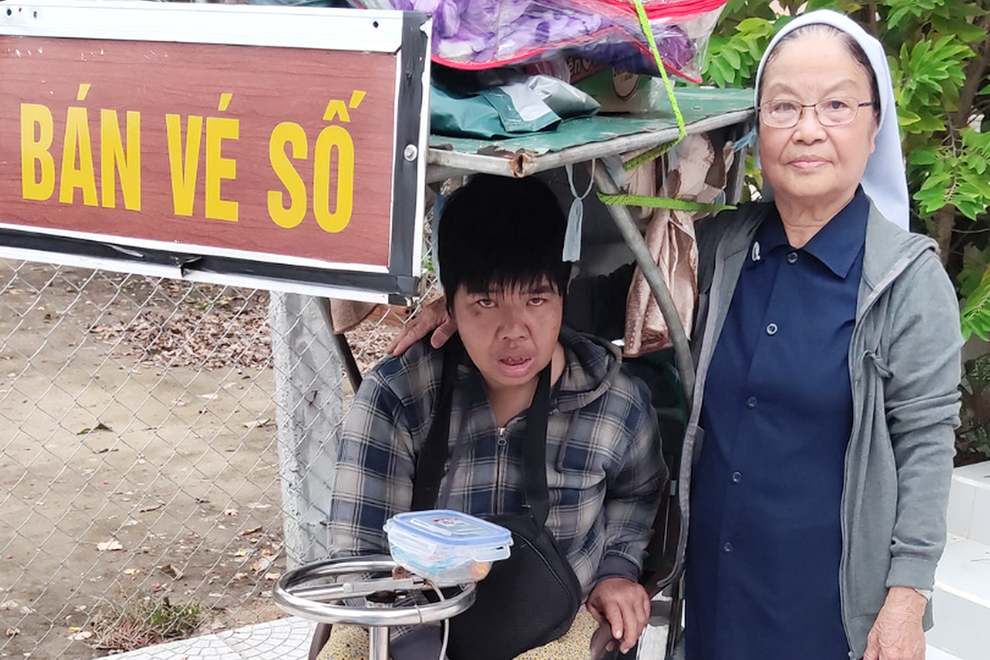Sr. Anna Le Thi Hue feeds disabled woman Sr. Anna Le Thi Hue gives food to a disabled woman who is forced to sell lottery tickets by her relative on Mar. 6 in Phu Loc district of Thua Thien Hue province. (Joachim Pham)